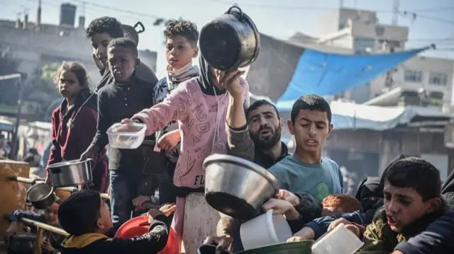 Palestinians receive food and humanitarian aid as Israeli airstrikes continue in Rafah, Gaza