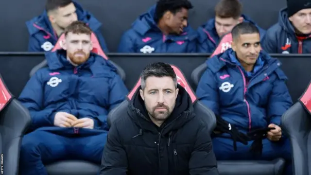 Alan Sheehan sits in the dugout with Swansea