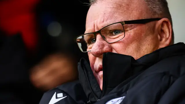 Steve Evans sits in the dugout