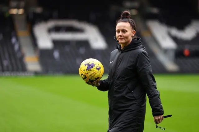 Referee Rebecca Welch holding a ball at Craven Cottage