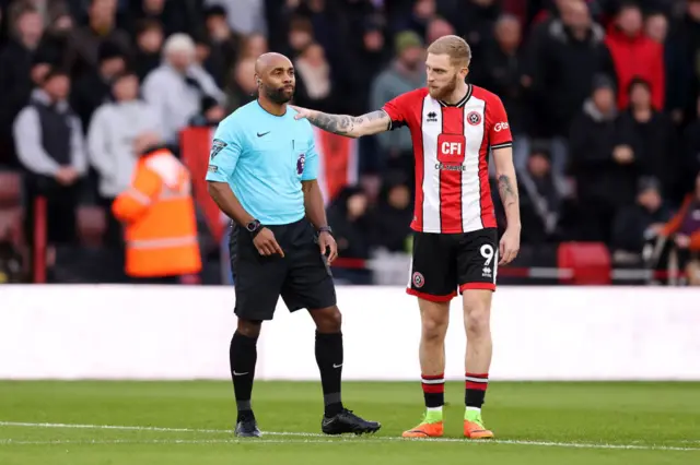 Oliver McBurnie and referee Sam Allison