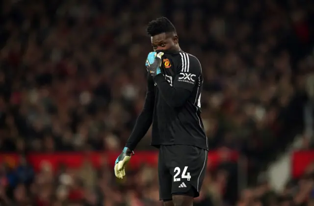 Onana wipes his face with his shirt after conceding the goal.