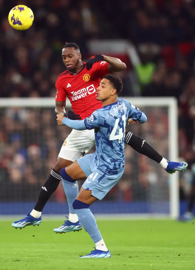 Ramsey and Wan-Bissaka duel for the ball in the air.