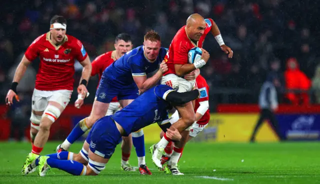 Munster's Simon Zebo is tackled by Ciaran Frawley and Max Deegan