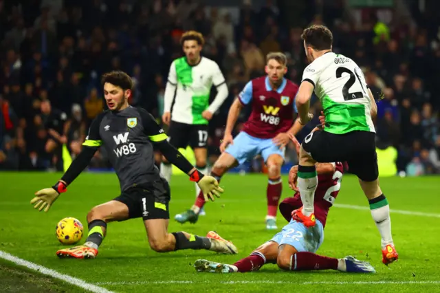 Jota thumps the ball past an on-rushing Trafford on the angle to seal the win for Liverpool.