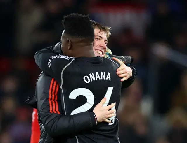 Hojlund and Onana embrace at full time after victory is sealed.