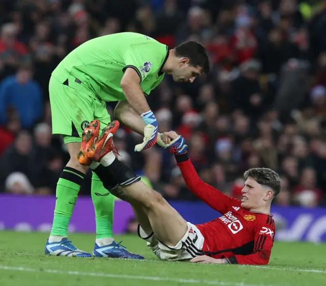 Garnacho is helped by Martinez as he lies in pain with cramp.