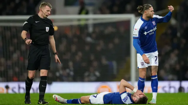 Ipswich's George Hirst lies injured against Leicester City