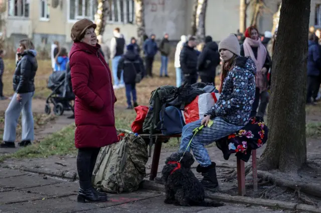 A woman and child stand with a dog