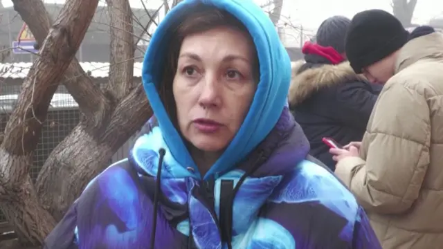 Woman wrapped up in patterned blue coat and blue hoodie