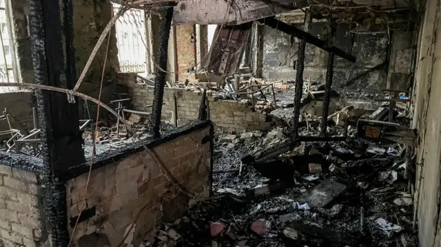 Scorched rubble lies at the bottom of a destroyed room in the building