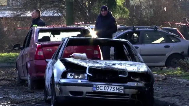 Damaged cars with windows blown out sit on Lviv road