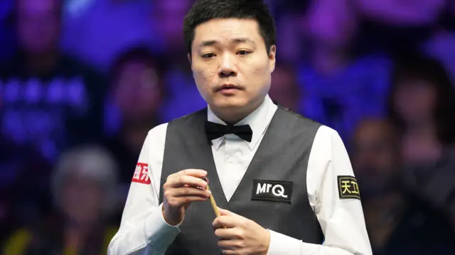 Ding Junhui chalks his cue