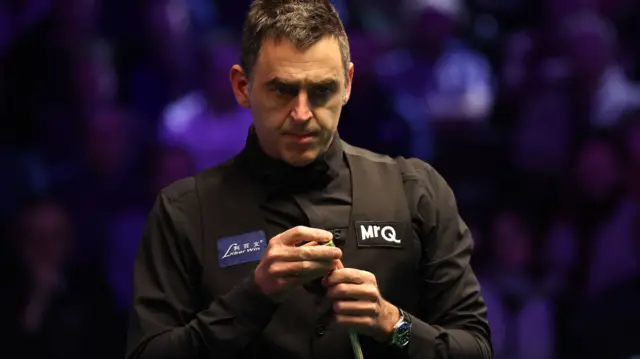 Ronnie O'Sullivan chalks his cue