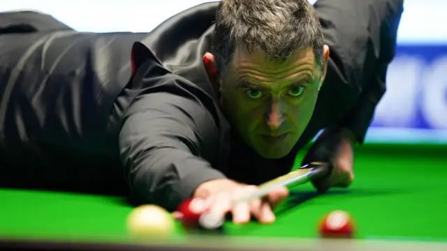 Ronnie O'Sullivan plays a shot