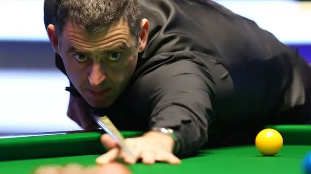 Ronnie O'Sullivan plays a shot