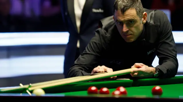 Ronnie O'Sullivan plays a shot with the rest