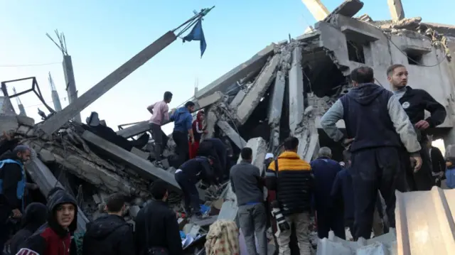 People inspect damaged building