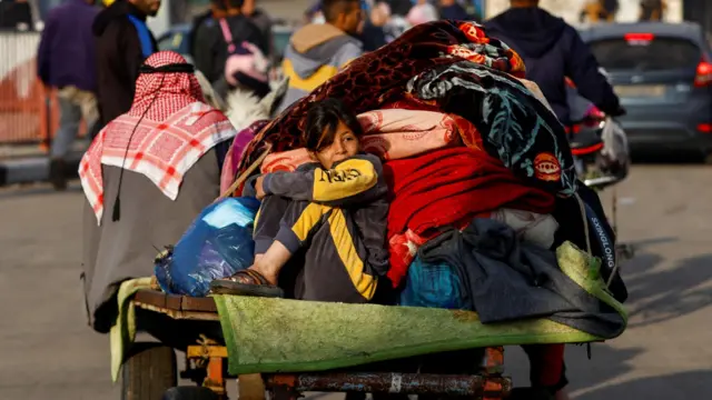 A child sits on a trailer, as Palestinians flee their houses due to Israeli strikes, after a temporary truce between Hamas and Israel expired