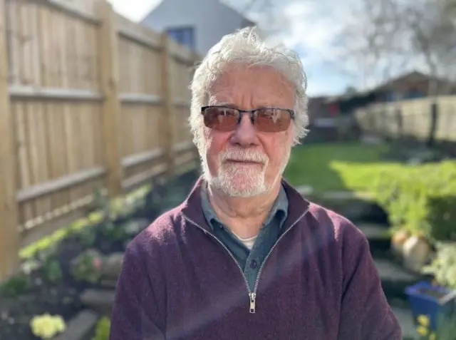 Roger Parish standing in his garden