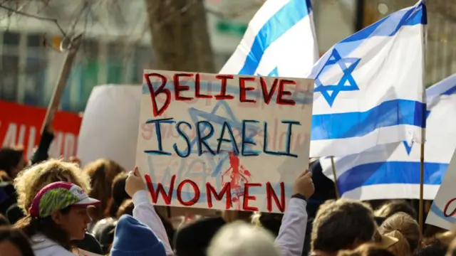 Demonstrators gather outside the UN headquarters with a sign saying "believe Israeli women", 4 December 2023