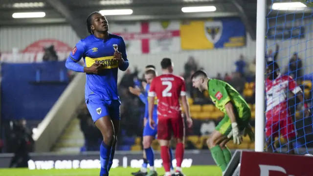 Josh Neufville celebrates scoring AFC Wimbledon's third goal against Ramsgate