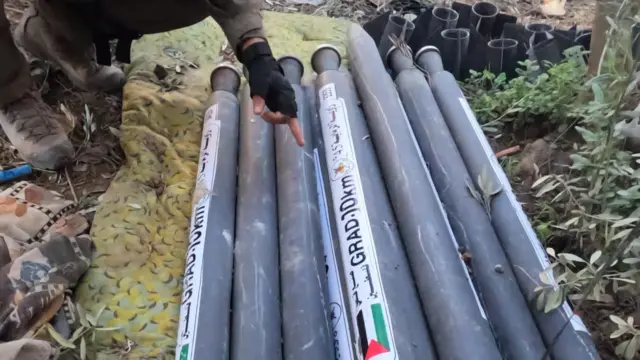 A soldier points at a number of rockets, bearing the Palestinian flag. The IDF shared this photo of rockets it says it located in the Gaza strip