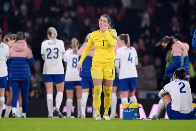 Earps walks dejected as Bronze sits on the floor the same.