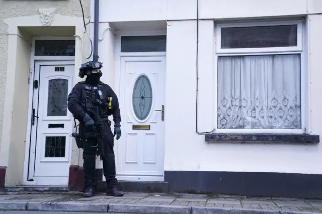 Officers remain outside a property in Wyndham Street, in Troedyrhiw