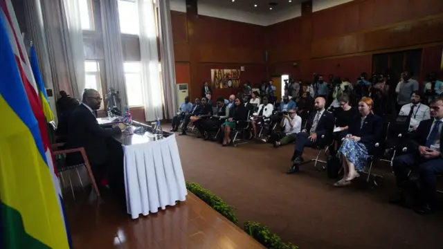 James Cleverly addresses a roomful of journalists in Rwanda