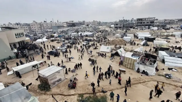 People walk through a makeshift community in al-Mawasi, on the southern coast of Gaza