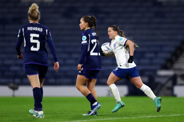 Kirby runs back to kick off with the ball as Scotland players trudge towards their positions.