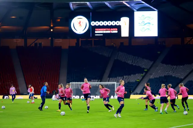 Scotland players warm up on the pitch at Hampden Park.