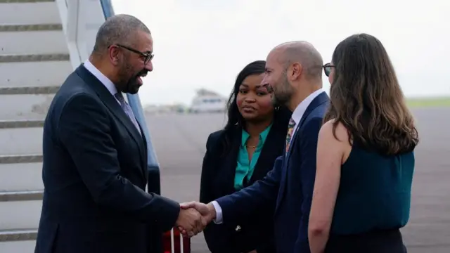 James Cleverly is greeted on the tarmac of an airport in Rwanda