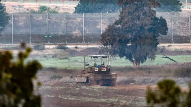 Israeli military vehicles drive near the border with the Gaza Strip on December 6, 2023, amid continuing battles between Israel and the militant group Hamas. Israeli forces were encircling southern Gaza's main city on Wednesday, battling Hamas militants through streets and buildings in some of the most intense combat of the two-month war.