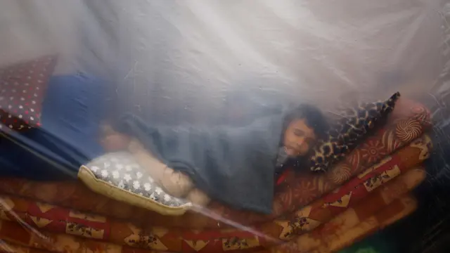 A child sleeps in a makeshift shelter in a new camp sheltering displaced Palestinians