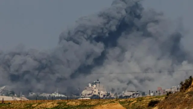 Smoke rises among buildings destroyed in Israeli strikes, amid the ongoing conflict between Israel and the Palestinian Islamist group Hamas, at the Israel-Gaza border as seen from southern Israel, December 6, 2023