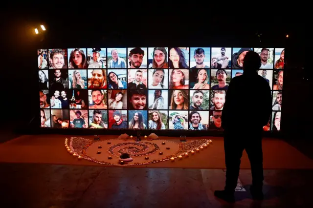 A man in Tel Aviv looks at pictures of people taken hostage at the Nova festival. Photo: 6 December 2023