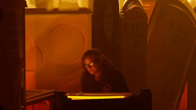 A woman in Tel Aviv looks at bullet holes on toilet cabins from the Supernova festival. Photo: 6 December 2023