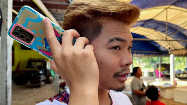 Anucha Angkaew, who was held in Hamas captivity for 50 days, listens to his phone from his family home in Thailand