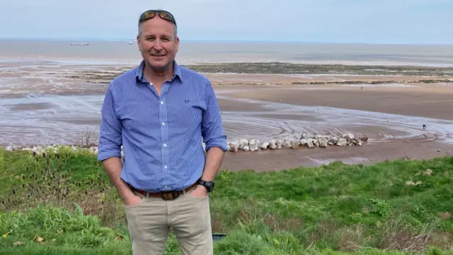 Councillor Mike Rigby standing on a coastal area