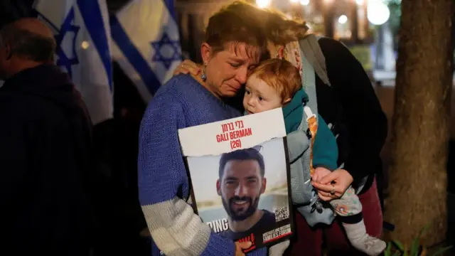 A family hold a sign up for a missing Israeli hostage