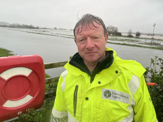 Ian Withers from the Environment Agency standing by a flooded waterway