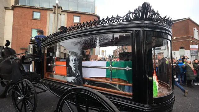 The funeral procession of Shane MacGowan starts from outside Shelbourne Park Stadium as it makes its way through the streets of Dublin ahead of his funeral in Co Tipperary.