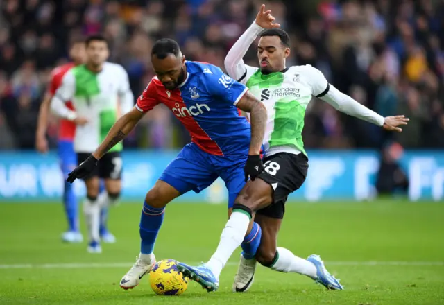 Jordan Ayew of Crystal Palace is challenged by Ryan Gravenberch