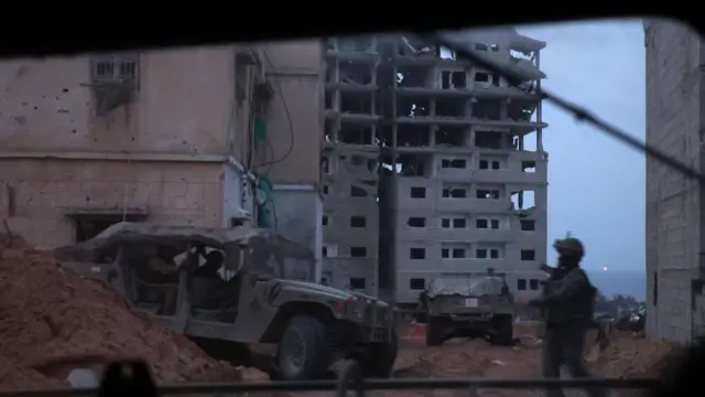 Israeli tranks and vehicles move between buildings