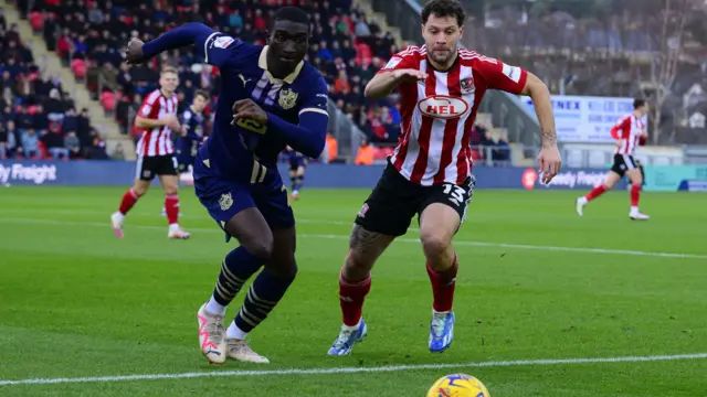 Yanic Wildschut of Exeter City battles for the ball with Jesse Debrah of Port Vale