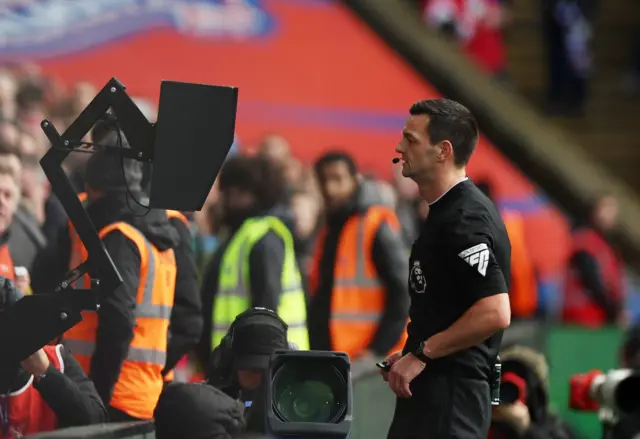 Referee Andy Madley looks at the VAR monitor