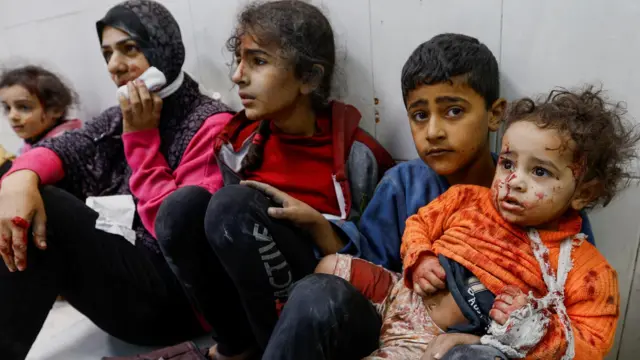 Wounded Palestinian children sit on the floor