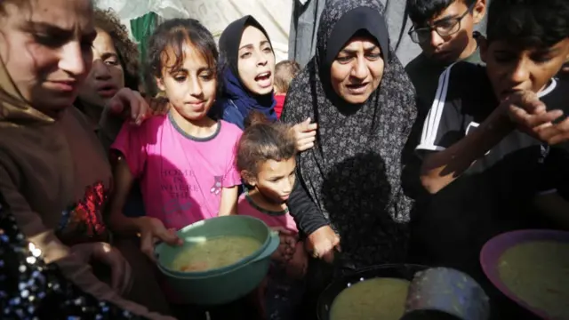 Displaced Palestinians are served food